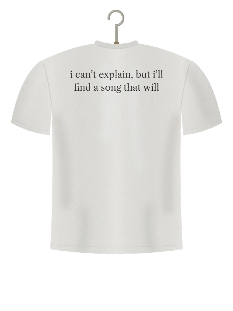 Find a Song That Will, off-white t-shirt on a hanger, back view: the words i can't explain, but i'll find a song that will, in small serif type across the shoulders