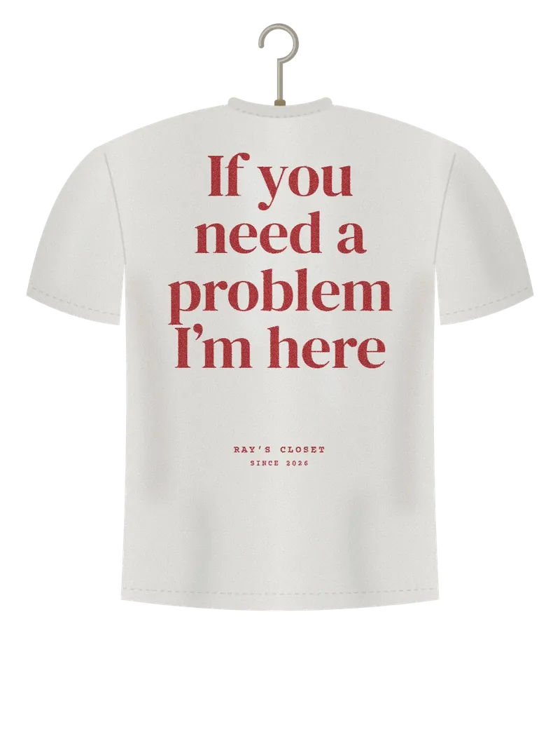 If You Need a Problem, I'm Here, off-white t-shirt on a hanger, back view: the words If you need a problem I'm here in large serif letters